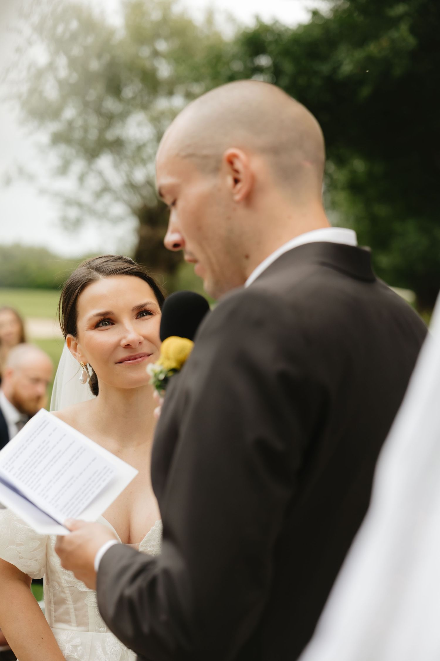 Couple sharing emotional moment during outdoor wedding vow exchange.