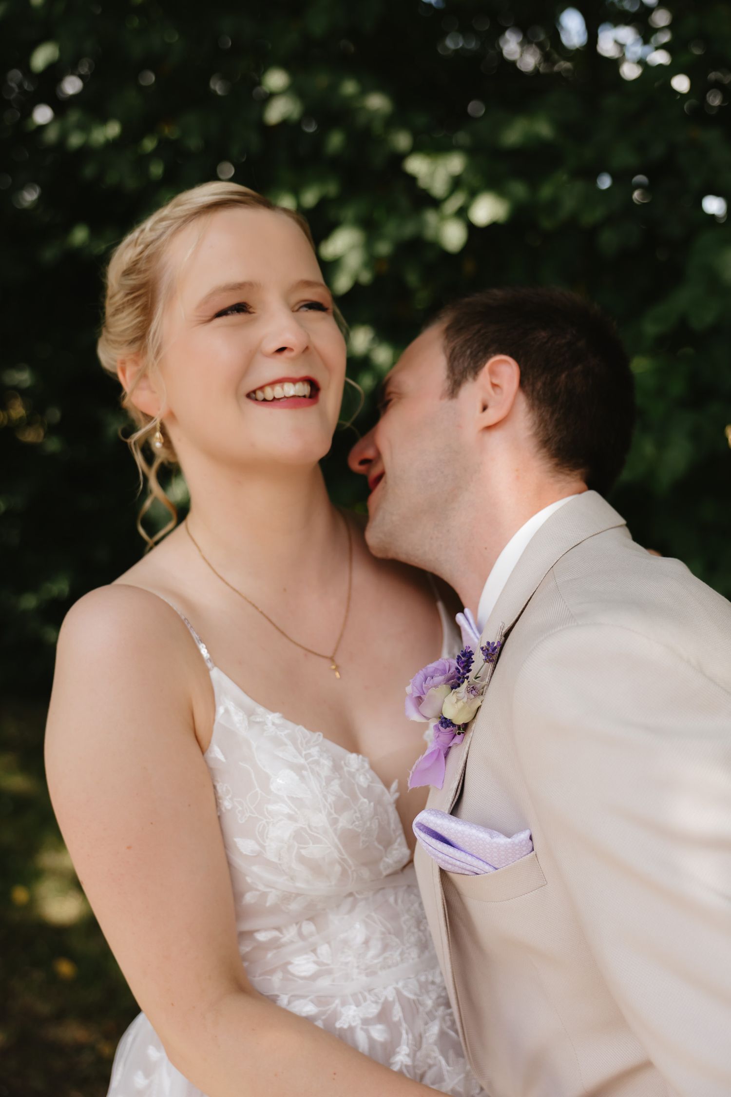 A romantic wedding couple shares an intimate moment in a garden setting with soft bokeh lighting effects.