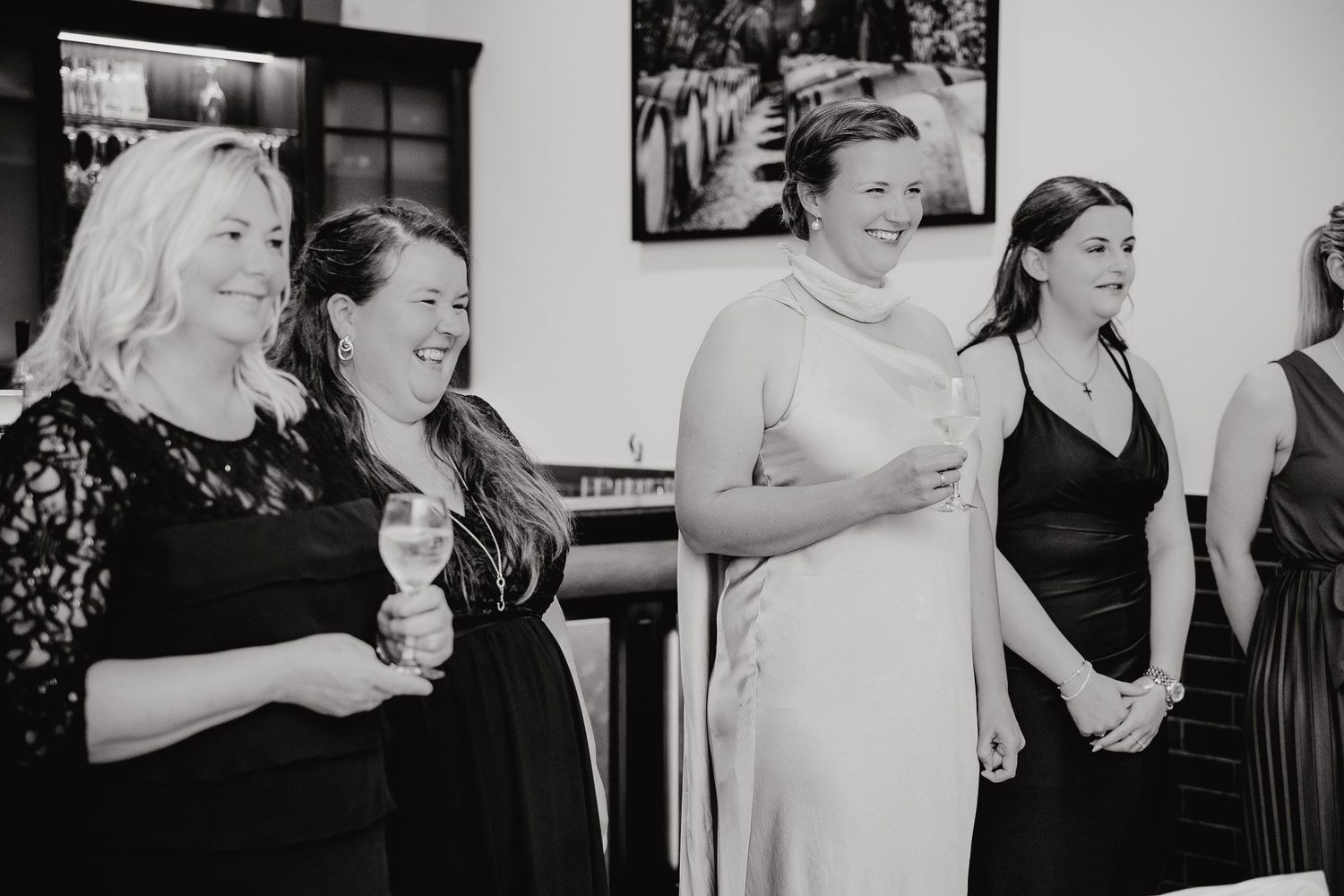 Black and white photo collage showing candid moments of people laughing and enjoying a celebration together.