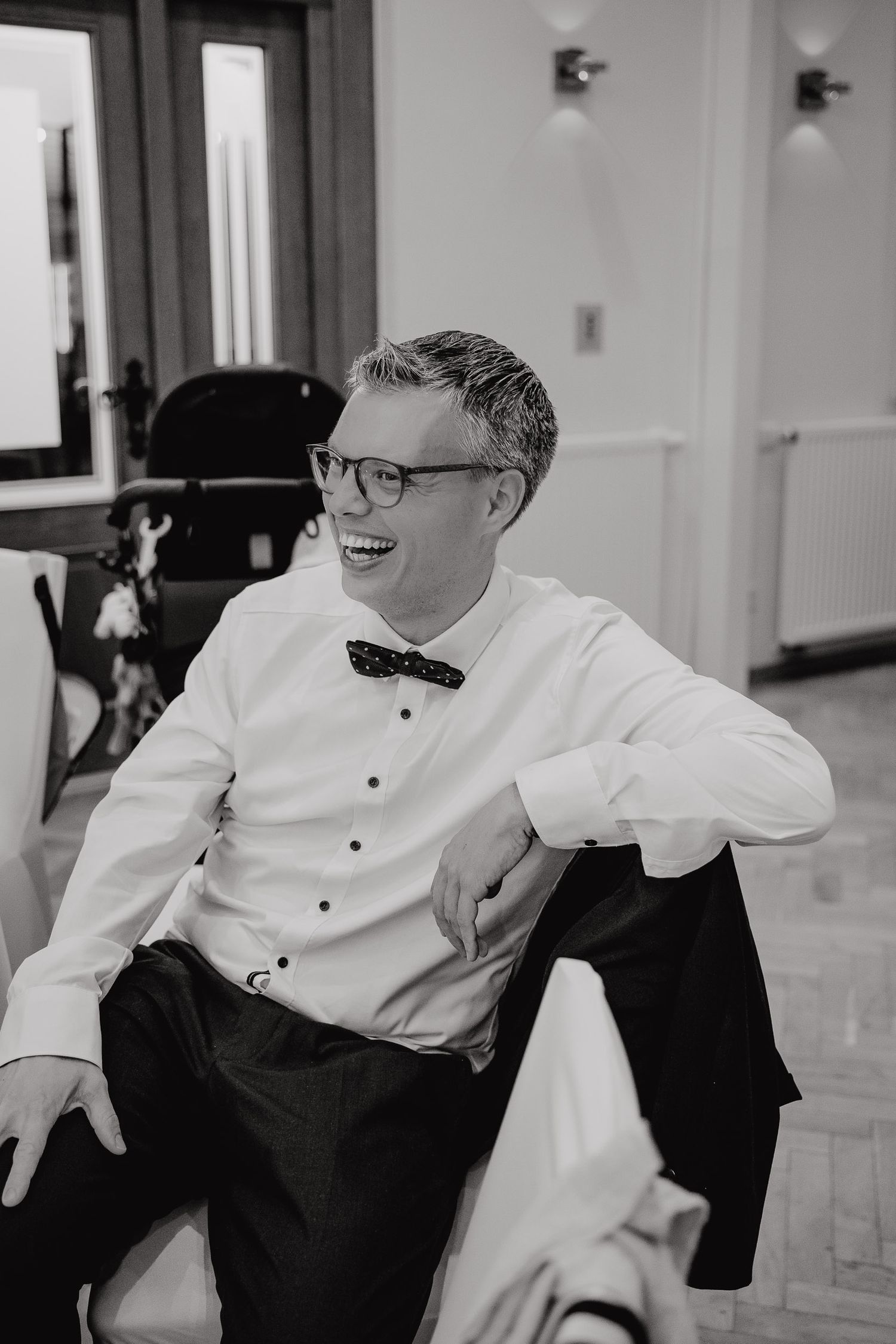 A black and white photo series shows three candid moments of laughter and joy at a formal event.