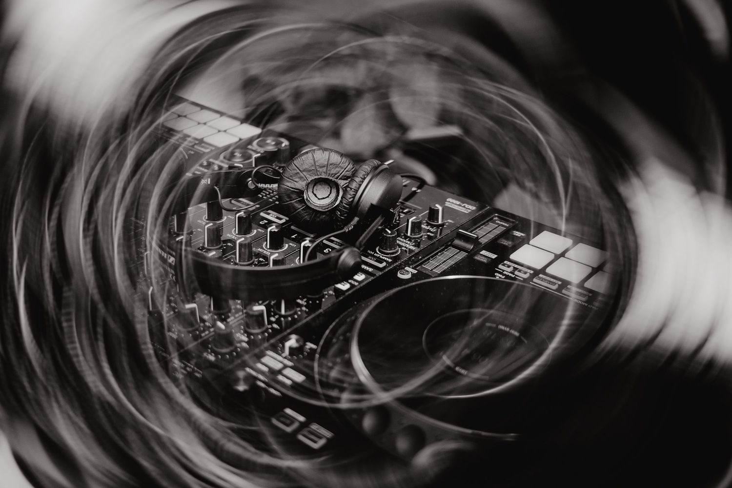 Black and white abstract swirling patterns create a hypnotic spiral effect in multiple connected circular designs.