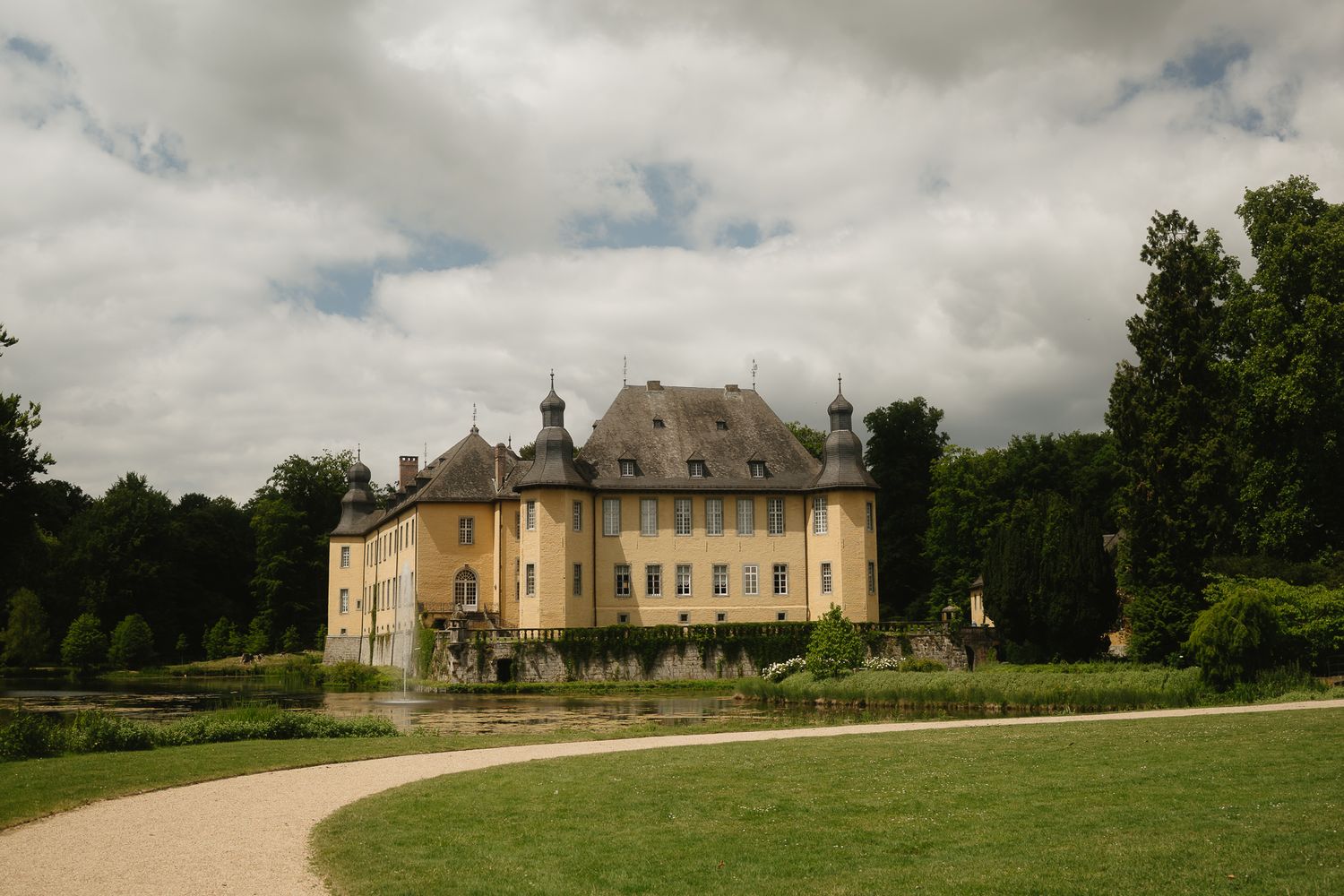 Panoramic view of an elegant French chateau surrounded by manicured grounds.