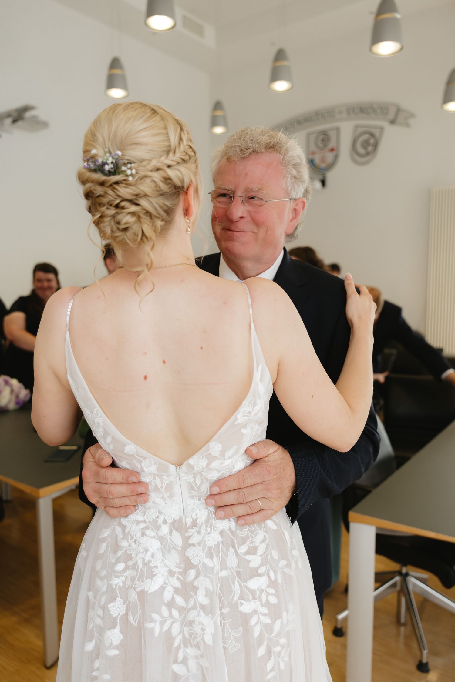 Close-up details of a white lace wedding dress with delicate button closures.