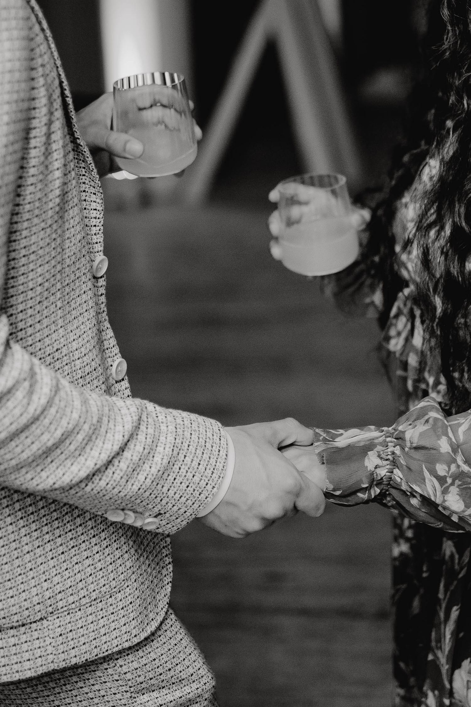 A series of black and white photos showing hands in knit sweater sleeves reaching for objects in dim lighting.
