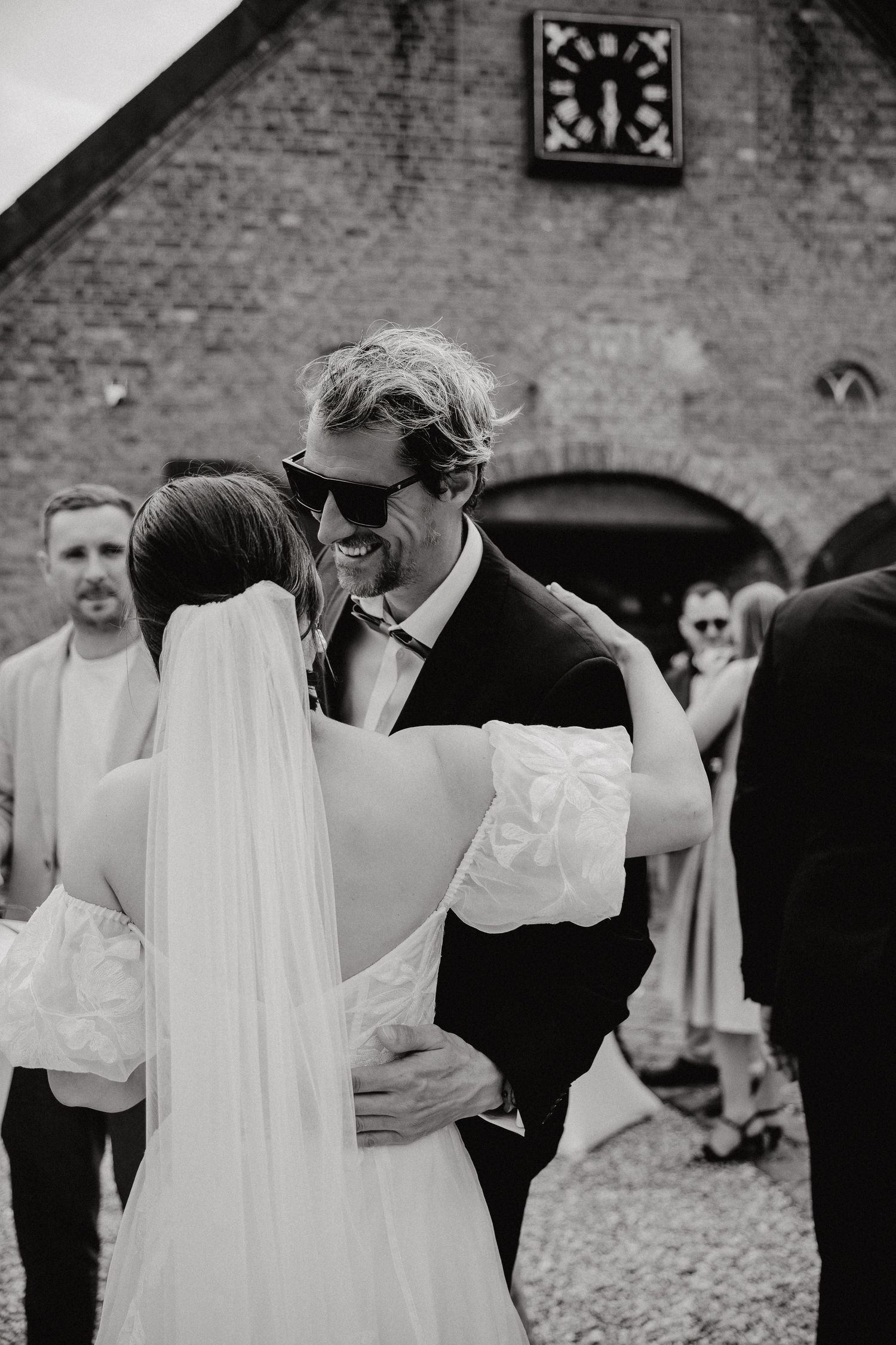 Intimate black and white wedding moments captured against brick architecture.