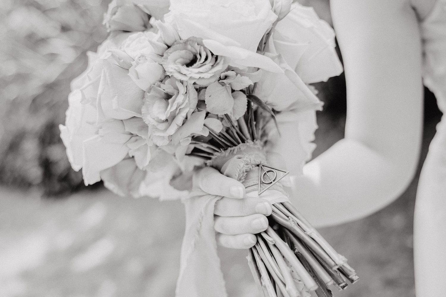 Black and white wedding photo collage showing close-up details of bridal bouquet with roses and floral arrangements.