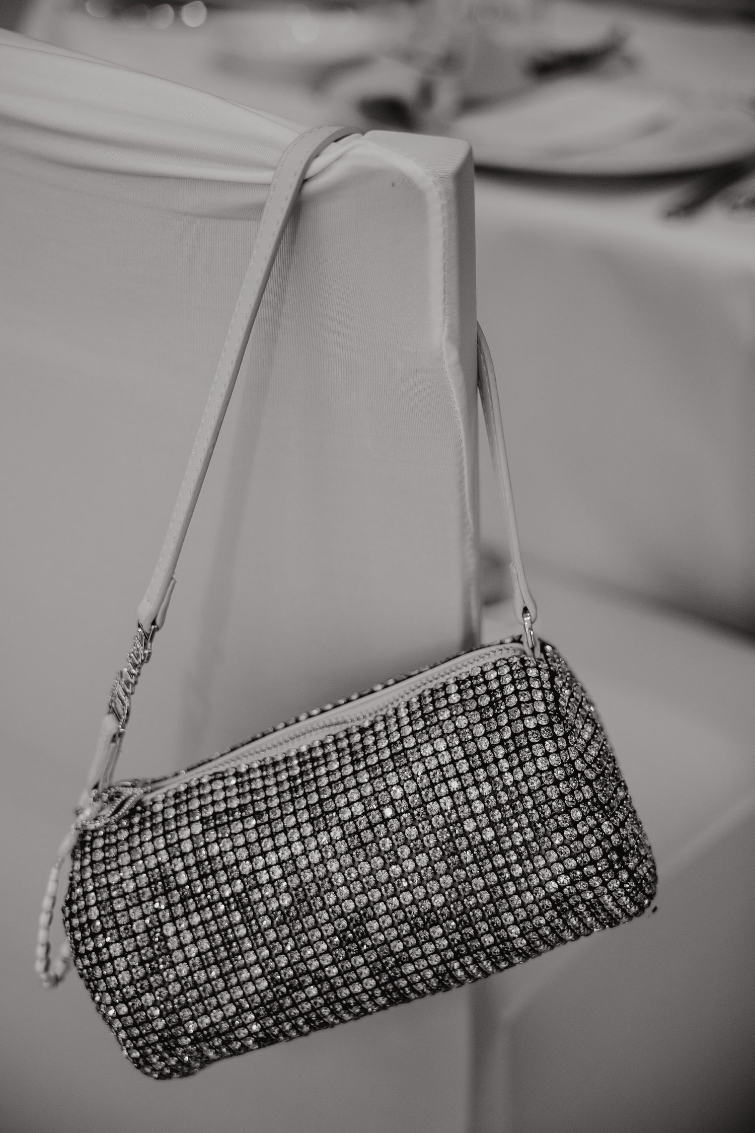 Black and white image sequence showing a sparkly rhinestone clutch purse being rotated against a blurred background.