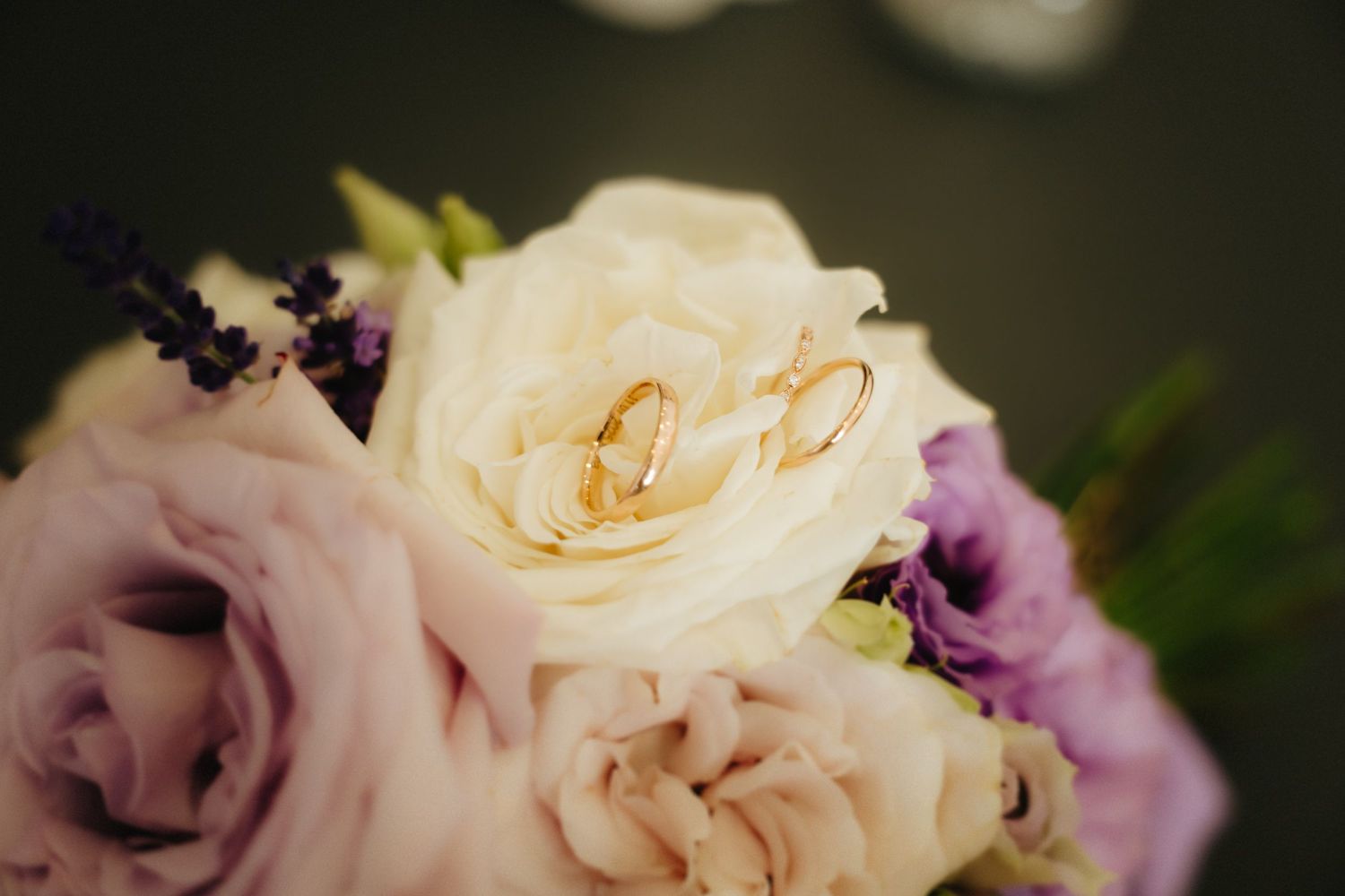 A delicate arrangement of cream and purple roses with soft petals creates an elegant floral display.