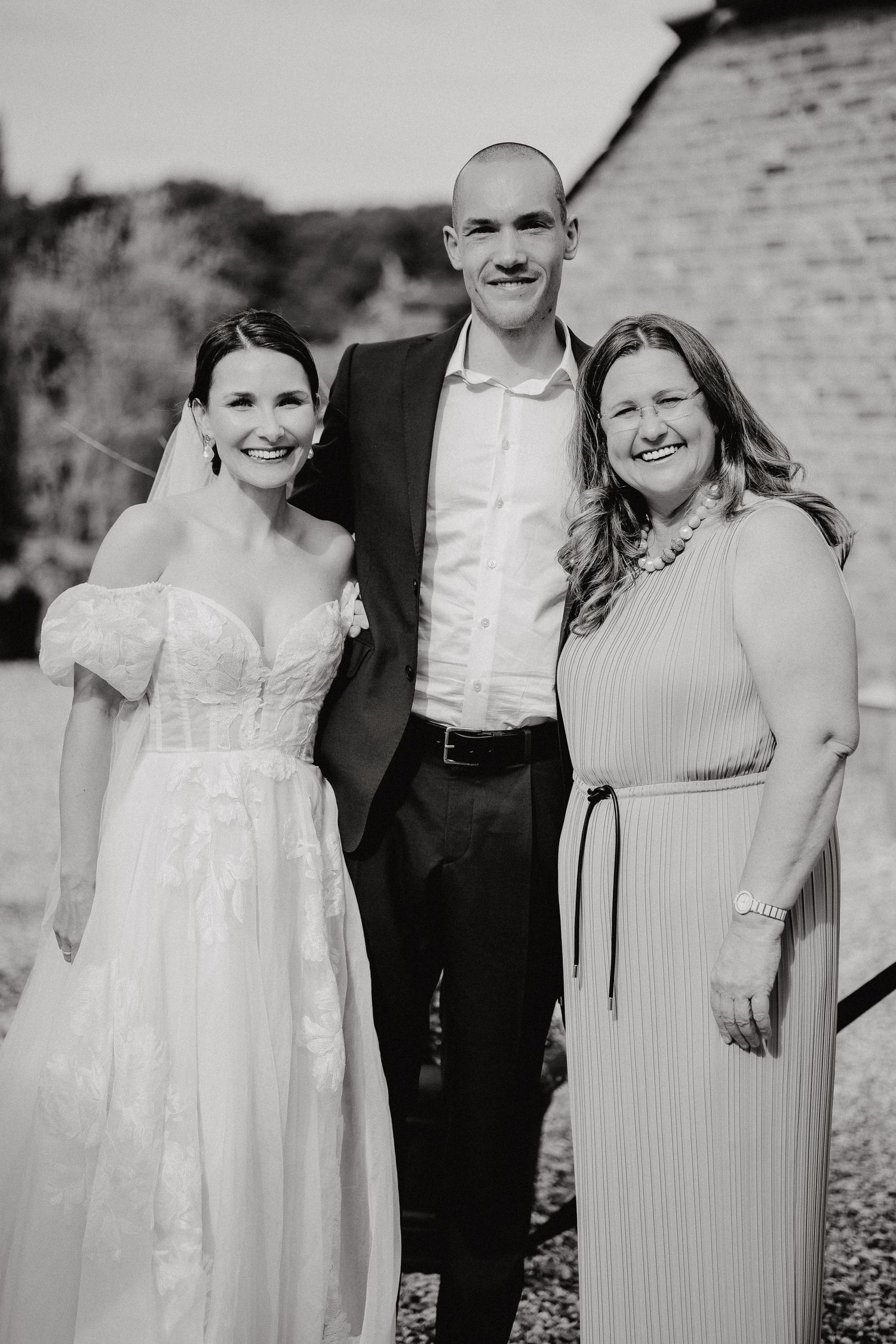 Wedding party poses together outdoors in formal attire.