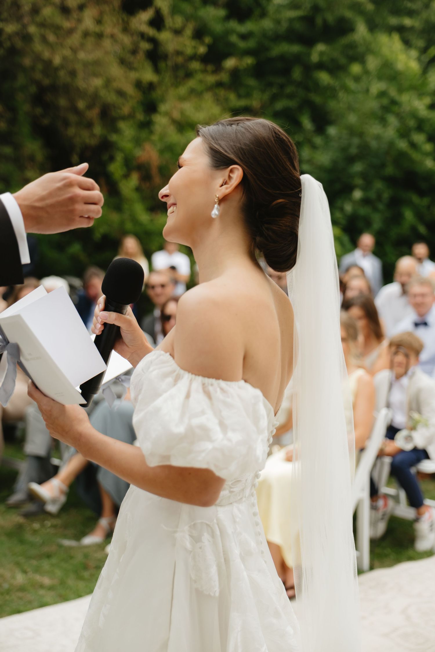 Outdoor wedding ceremony with guests watching couple exchange vows.