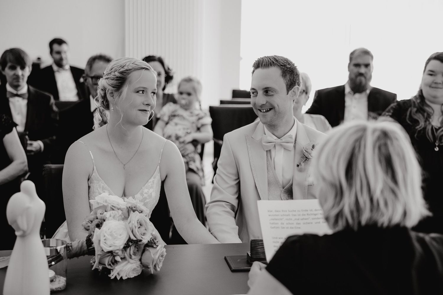 A collection of black and white wedding photos showing candid moments during a reception celebration.