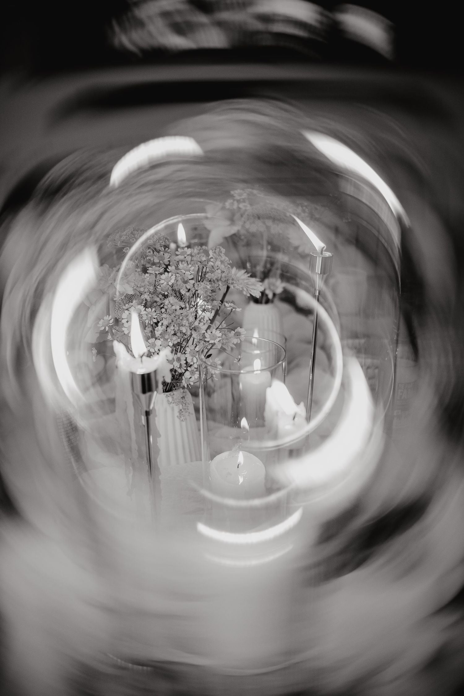 Abstract black and white photograph showing a swirling, distorted view through what appears to be a glass sphere or lens.