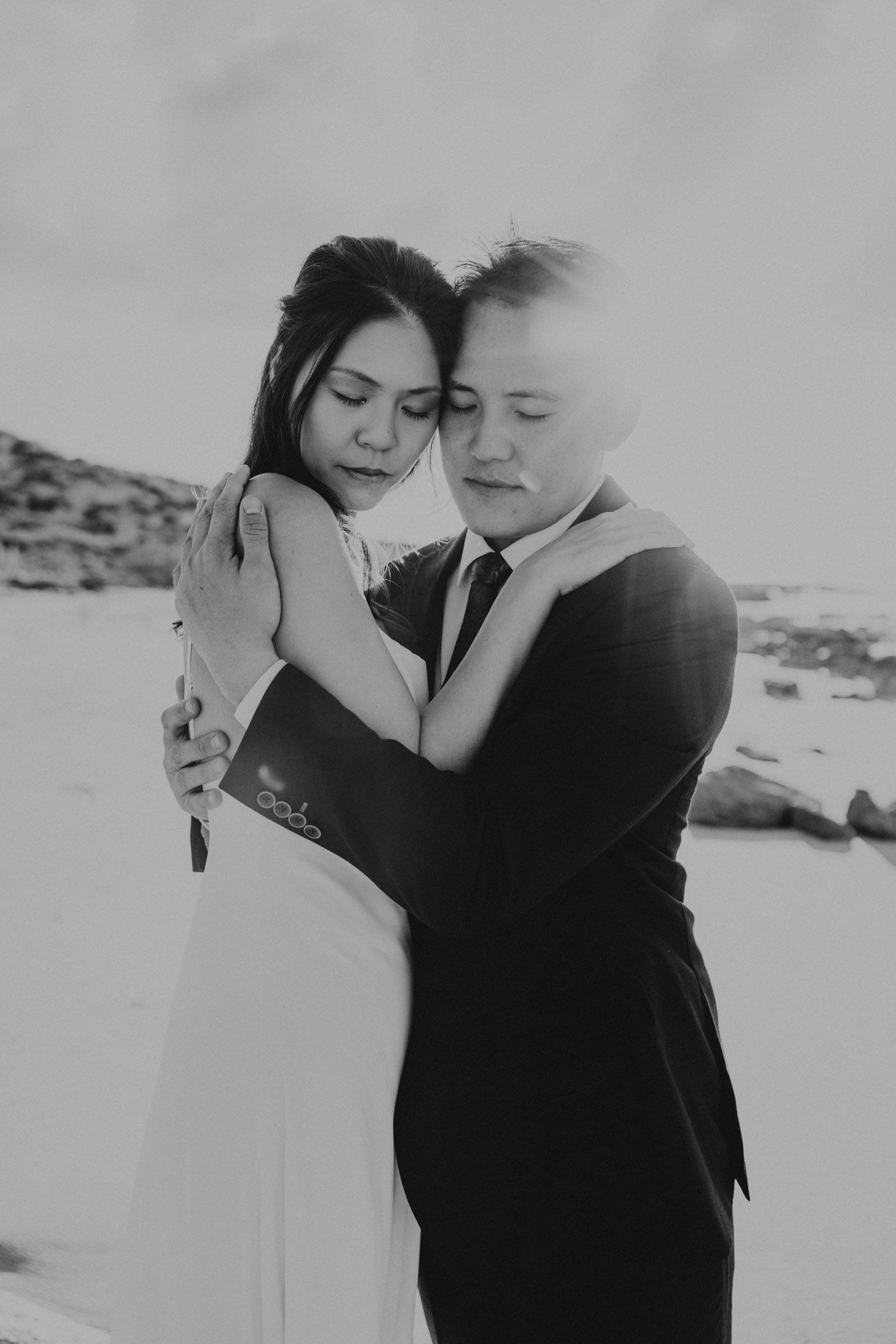 Bride and Groom embracing, elopement portrait photographs at sunset on a beach near to Exmouth, WA