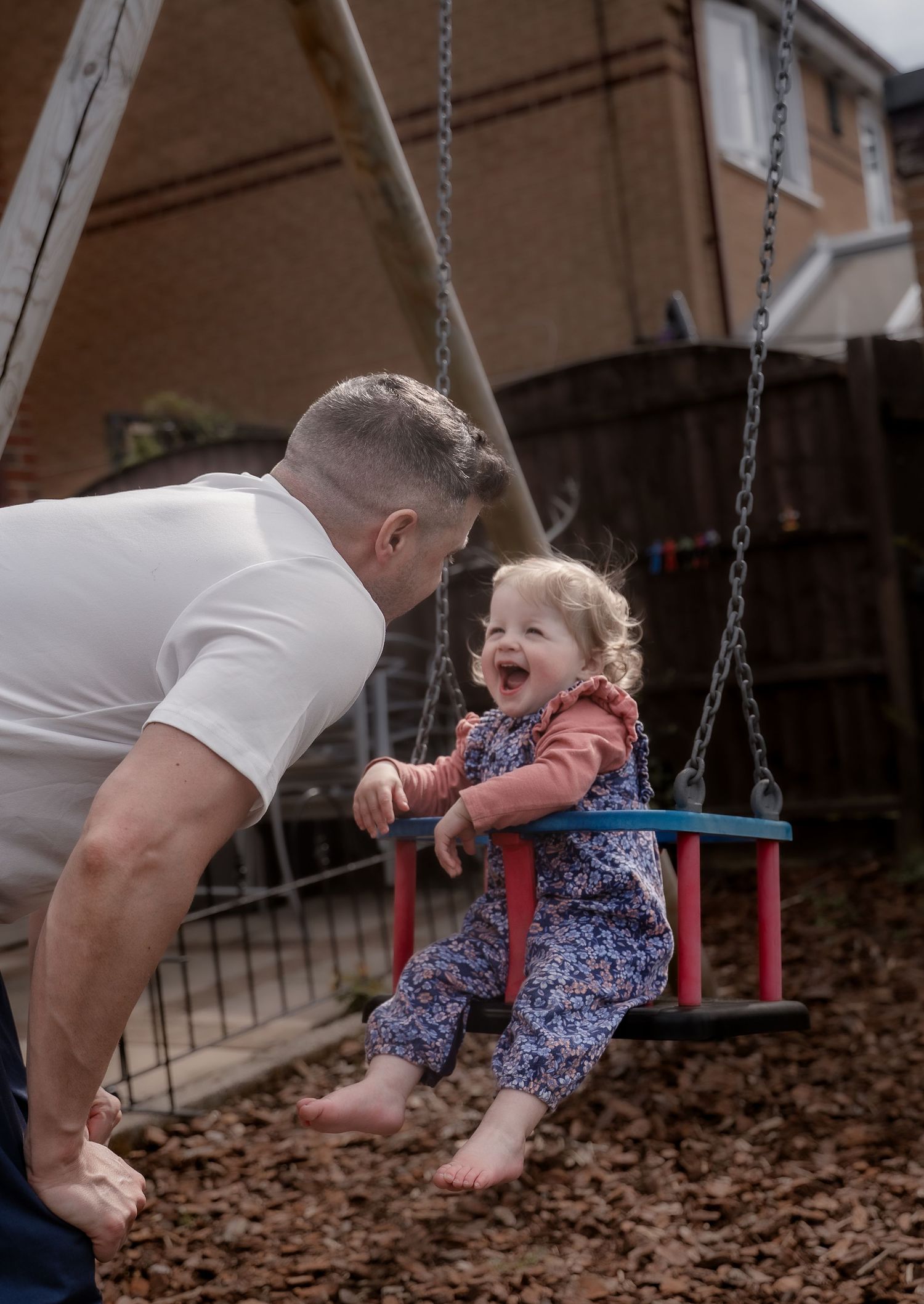 A series of photos showing a child being pushed on a colorful playground swing by an adult on an autumn day.