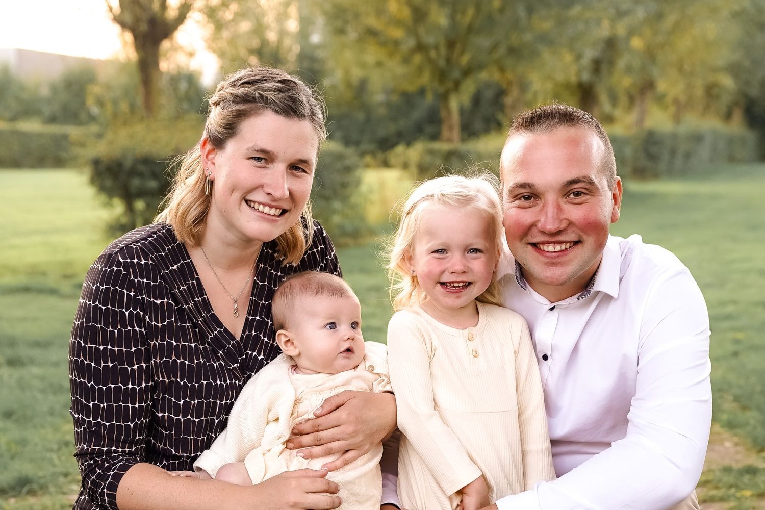 Outdoor family portrait taken in a natural setting during golden hour.