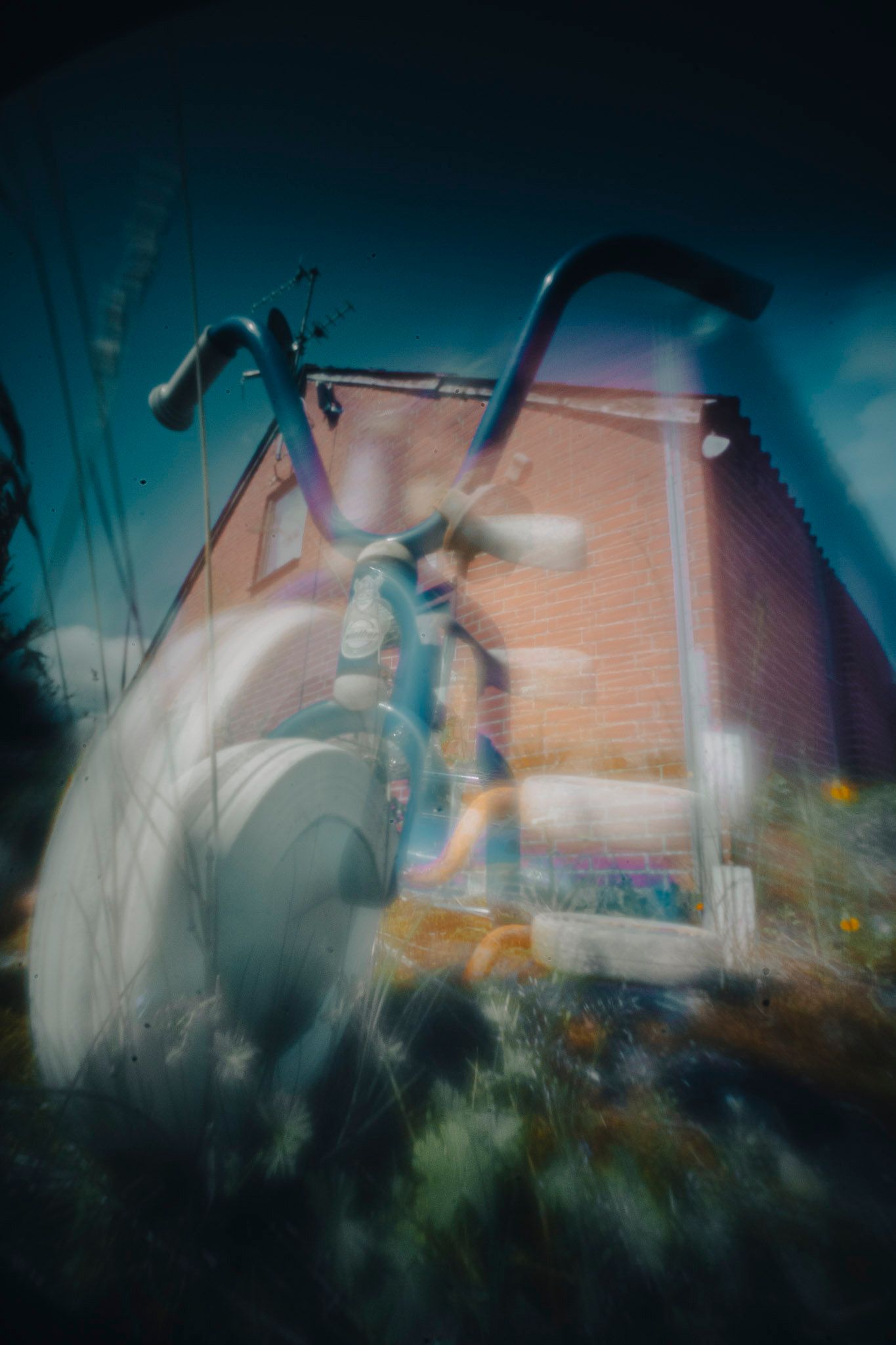 Fotokunst visende en trehjulet cykel foran en bygning