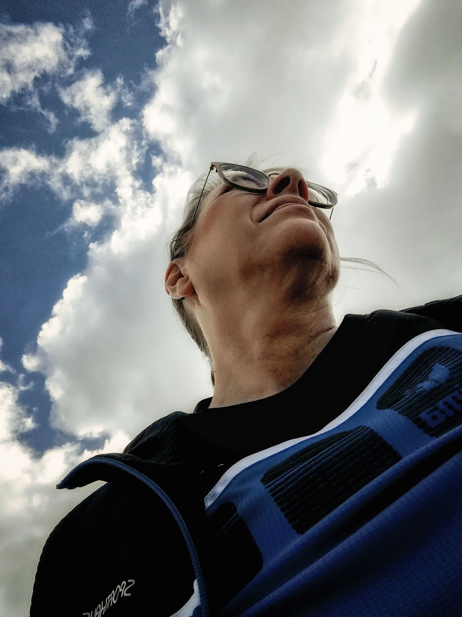 Portraitfoto Aurelia Schulz von unten fotografiert mit Himmel und Wolken als Hintergrund zur Seite  blickend im VFL Wolfhagen Trikot
