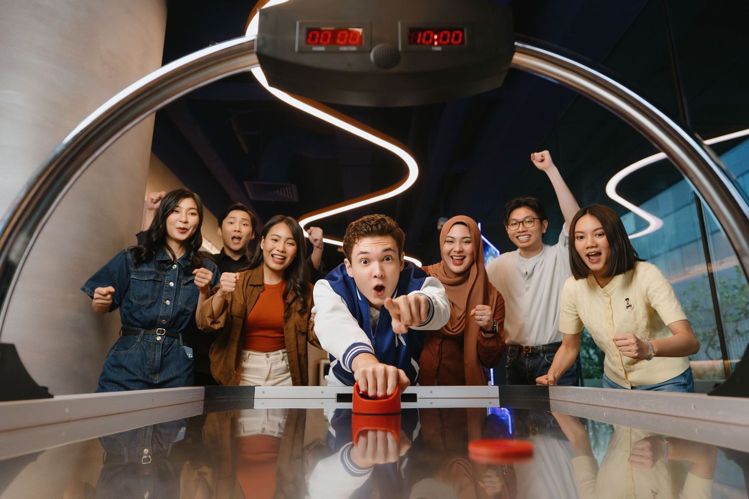 A group of people enjoying themselves inside what appears to be a futuristic pod or capsule with curved white walls.