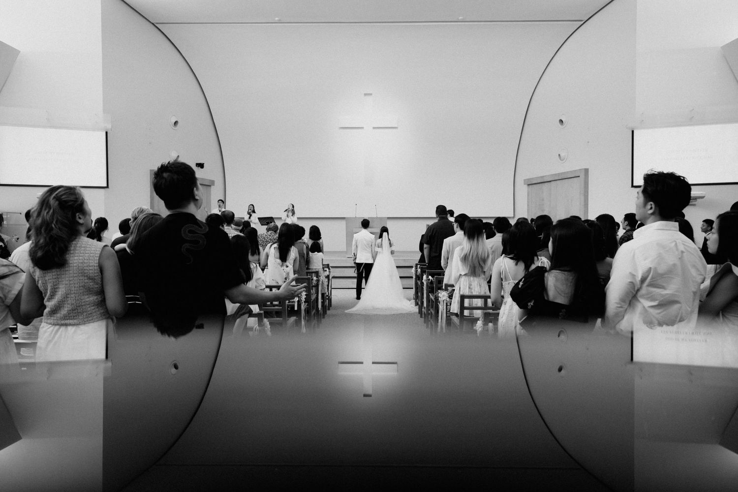 A minimalist gallery installation showing a sequence of black and white photographs mounted on white walls.