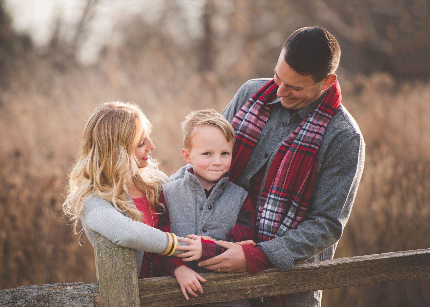 Family of three bundled up in a winter field