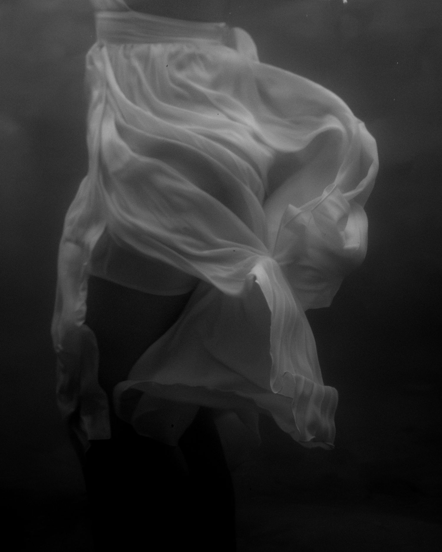 A series of black and white photographs showing ethereal smoke patterns swirling against a dark background.