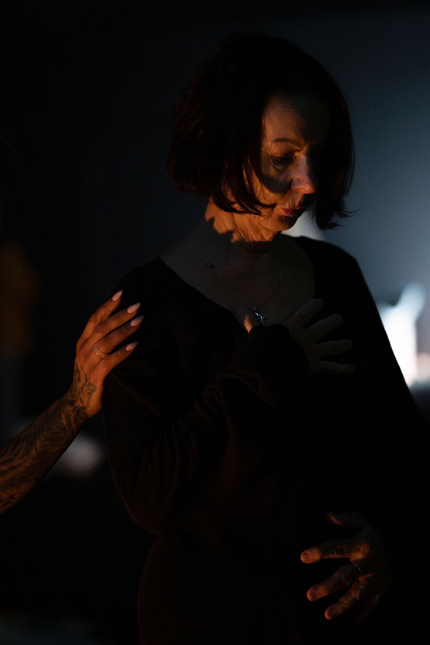 A silhouette of someone smoking in a dark environment with dramatic lighting effects.