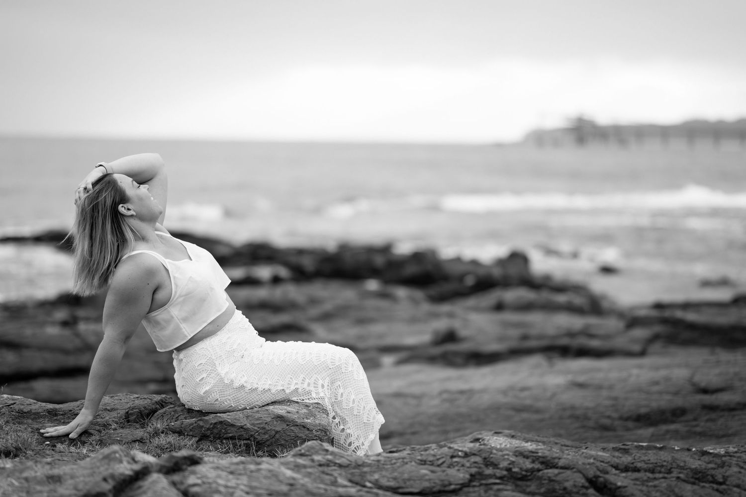 A black and white panoramic sequence of waves crashing against rocky coastal cliffs at the ocean's edge.
