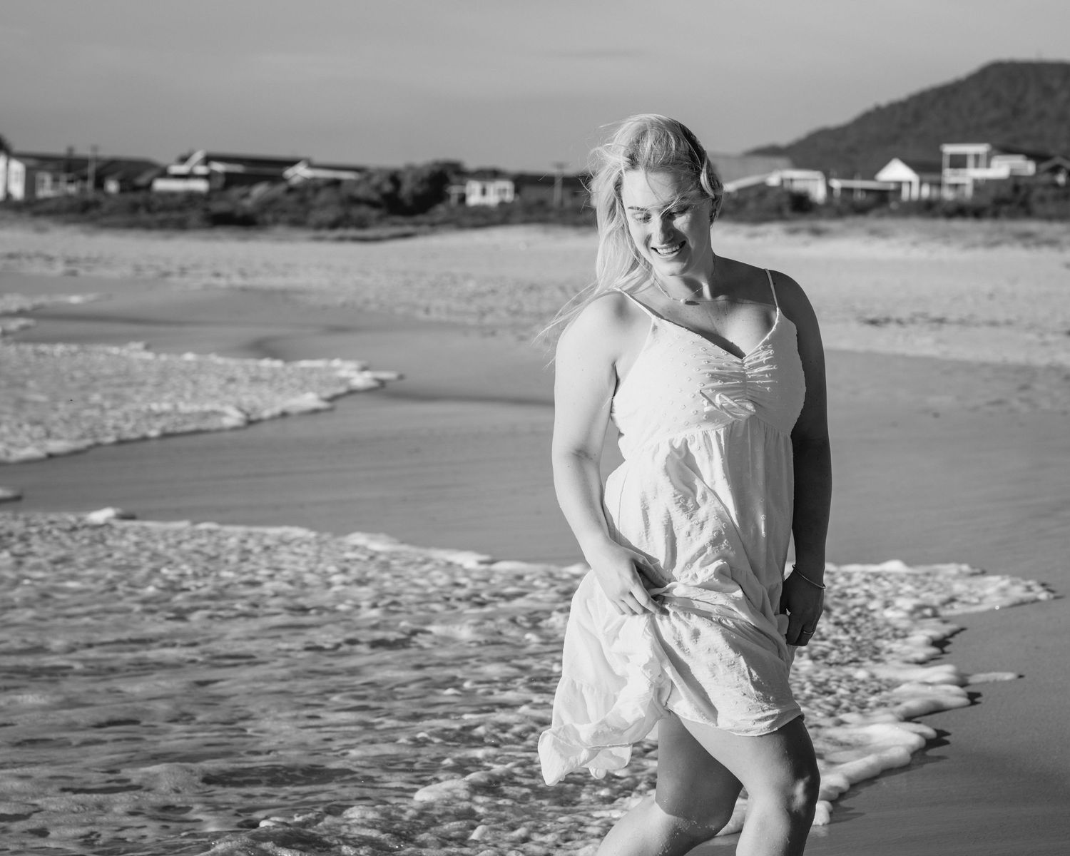 A series of black and white beach photographs showing romantic moments along the shoreline at sunset.