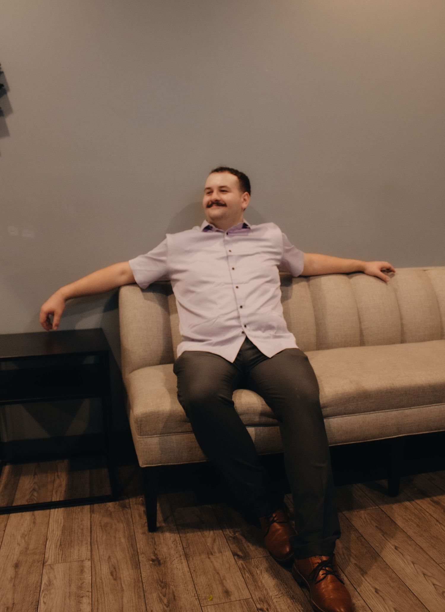 Person relaxing on a beige couch in a modern room setting.