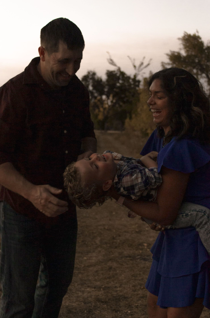 A couple shares an intimate moment together outdoors during sunset.