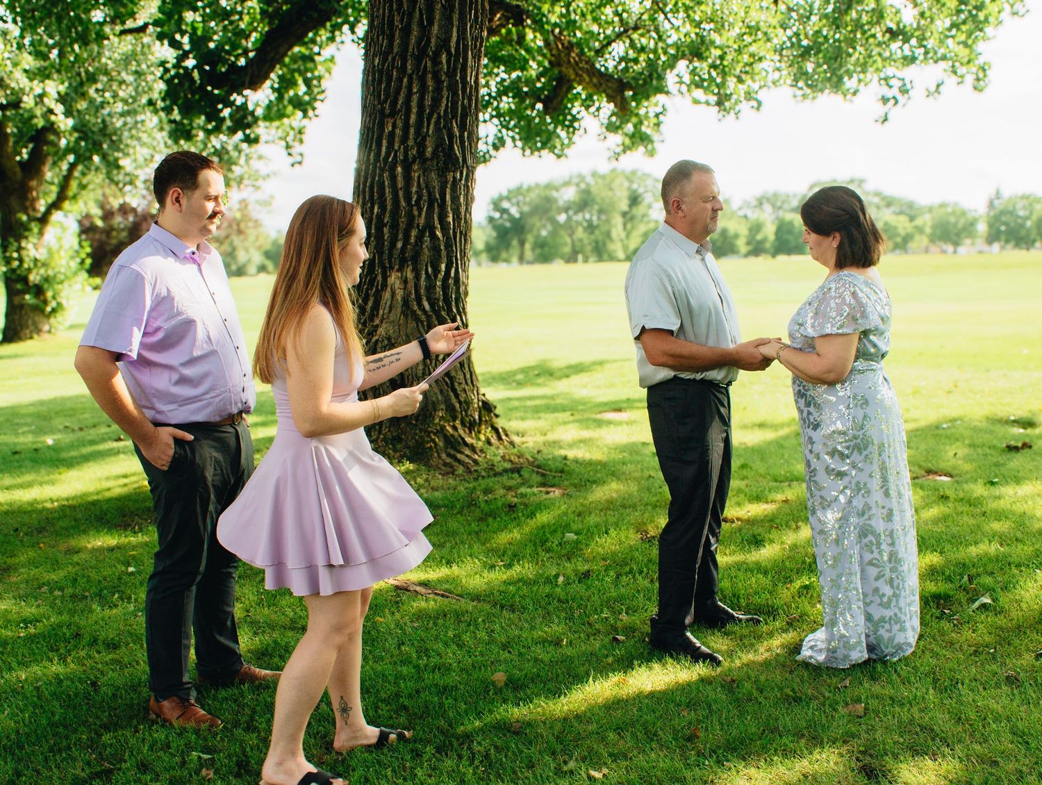 Family photo session taking place outdoors on a sunny summer day.