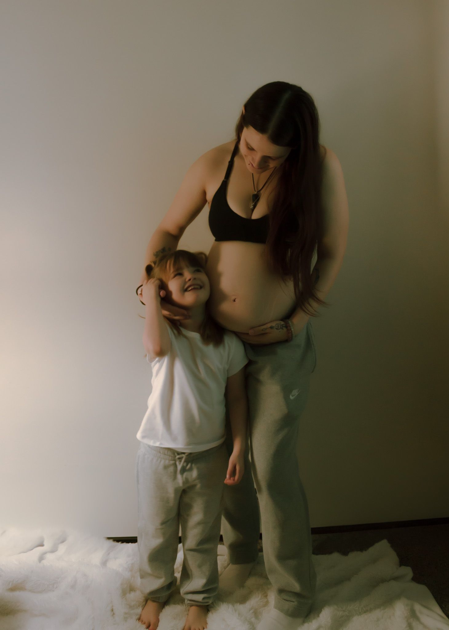 Parent and child share tender moments together in casual indoor setting.