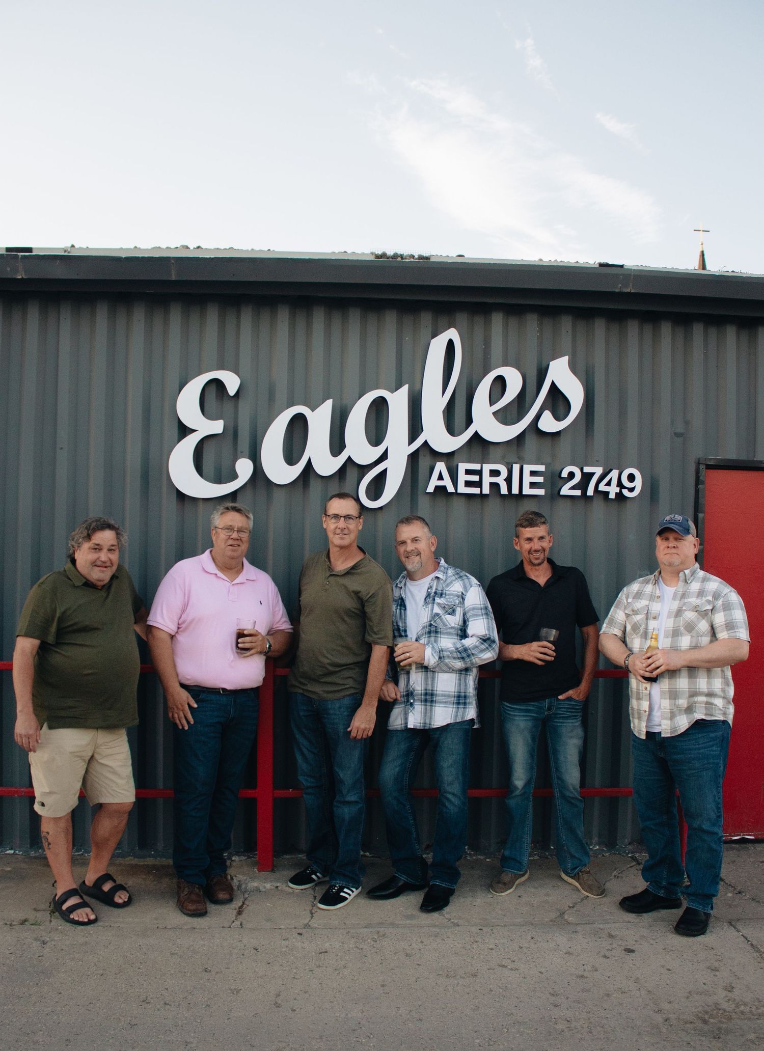 A row of people seated against a gray wall with 'Eagles' signage visible.