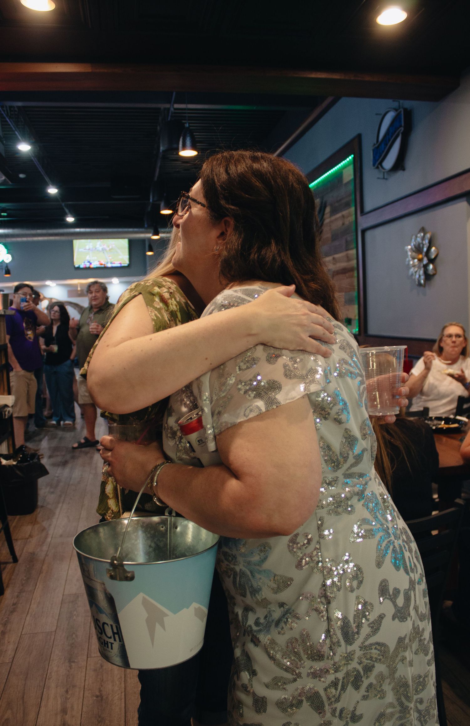 People embracing and dancing at an indoor celebration event.