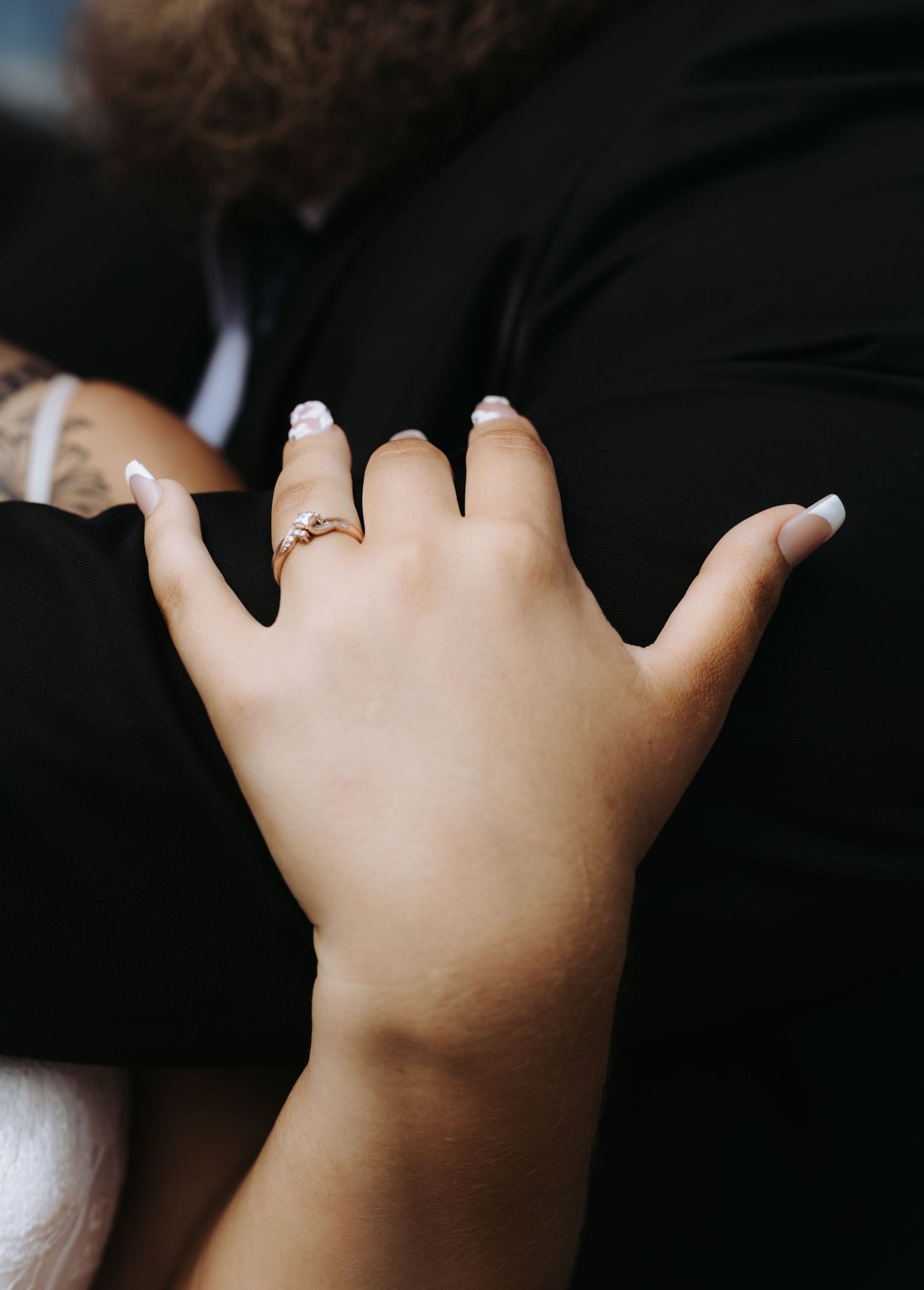 Close-up artistic shots of hands with wedding rings against dark background.