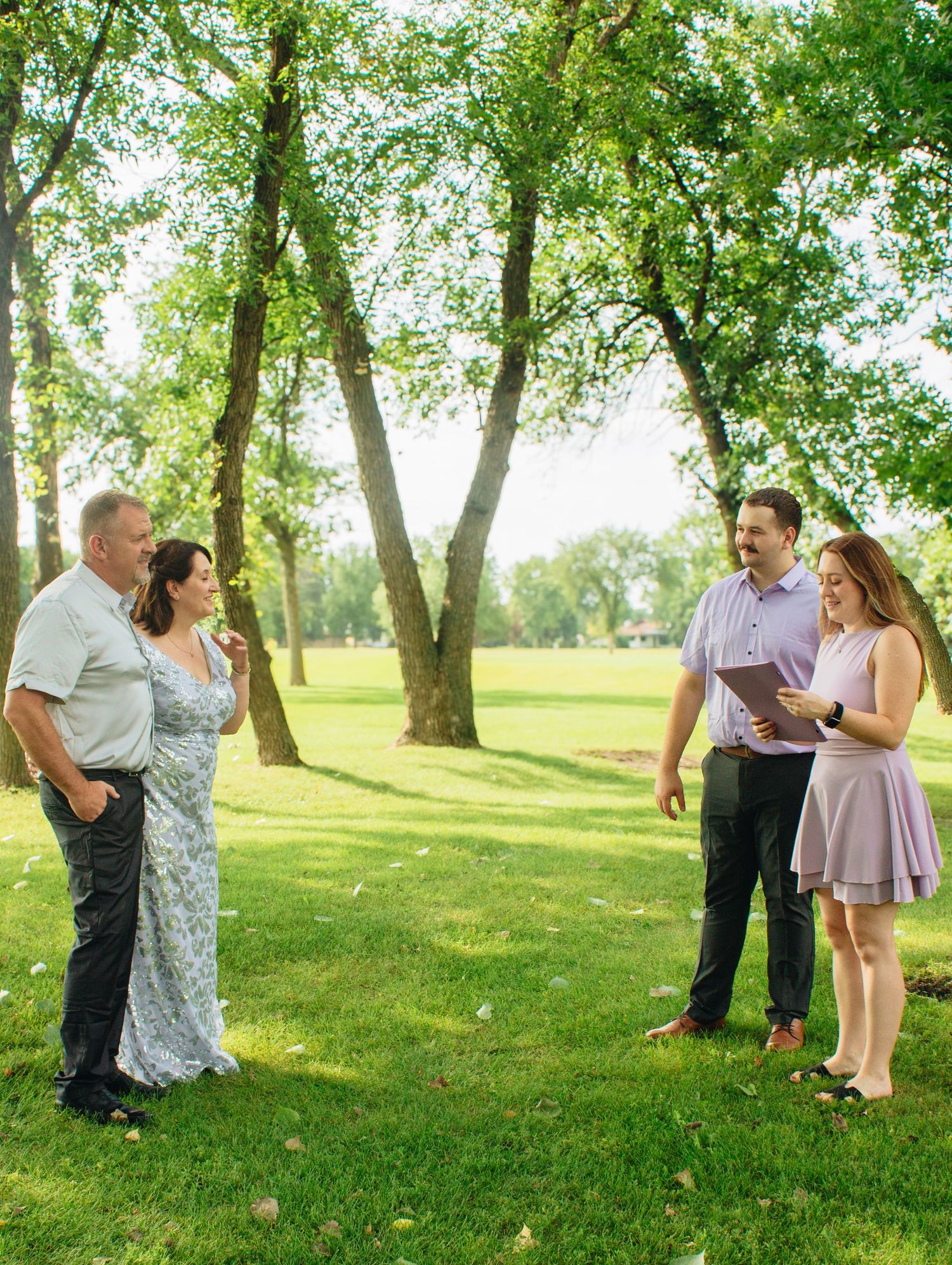 Family photo session taking place outdoors on a sunny summer day.