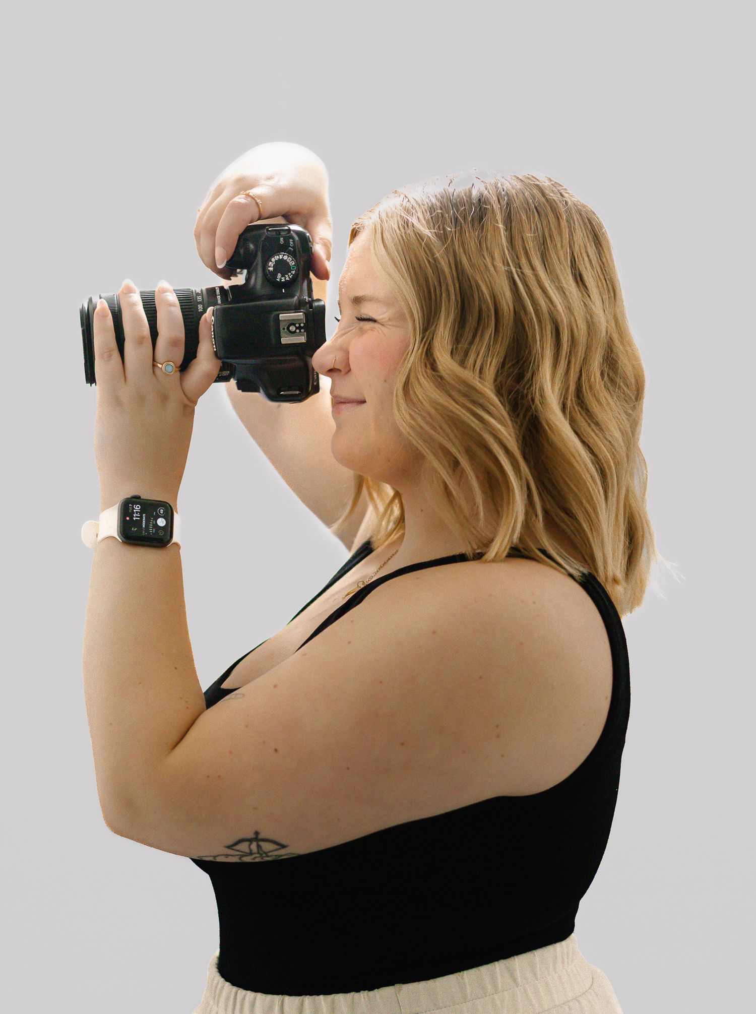 Side view of photographer holding camera in various poses against grey backdrop.