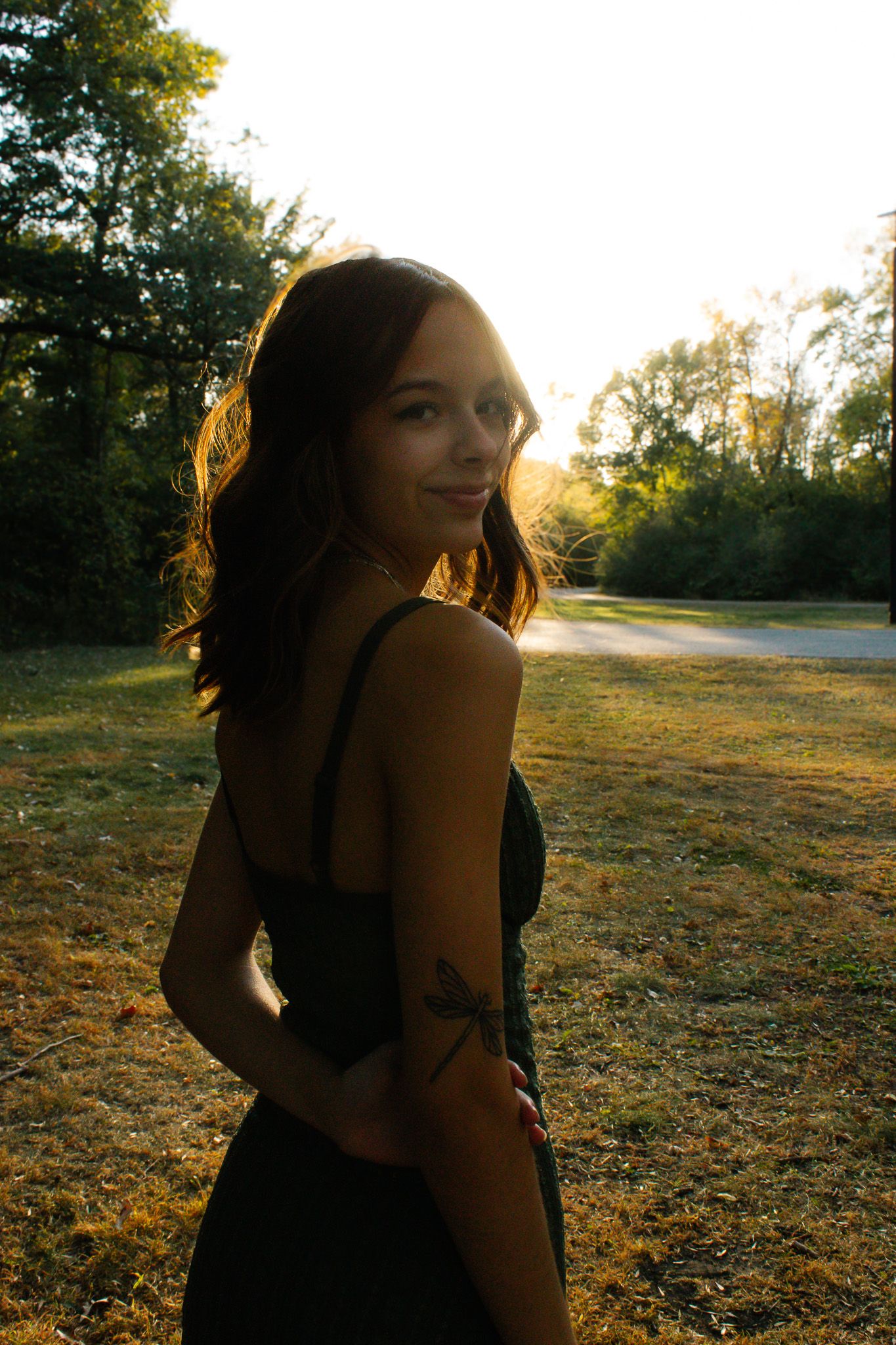 A golden sunset illuminates a figure in silhouette against a natural outdoor backdrop.