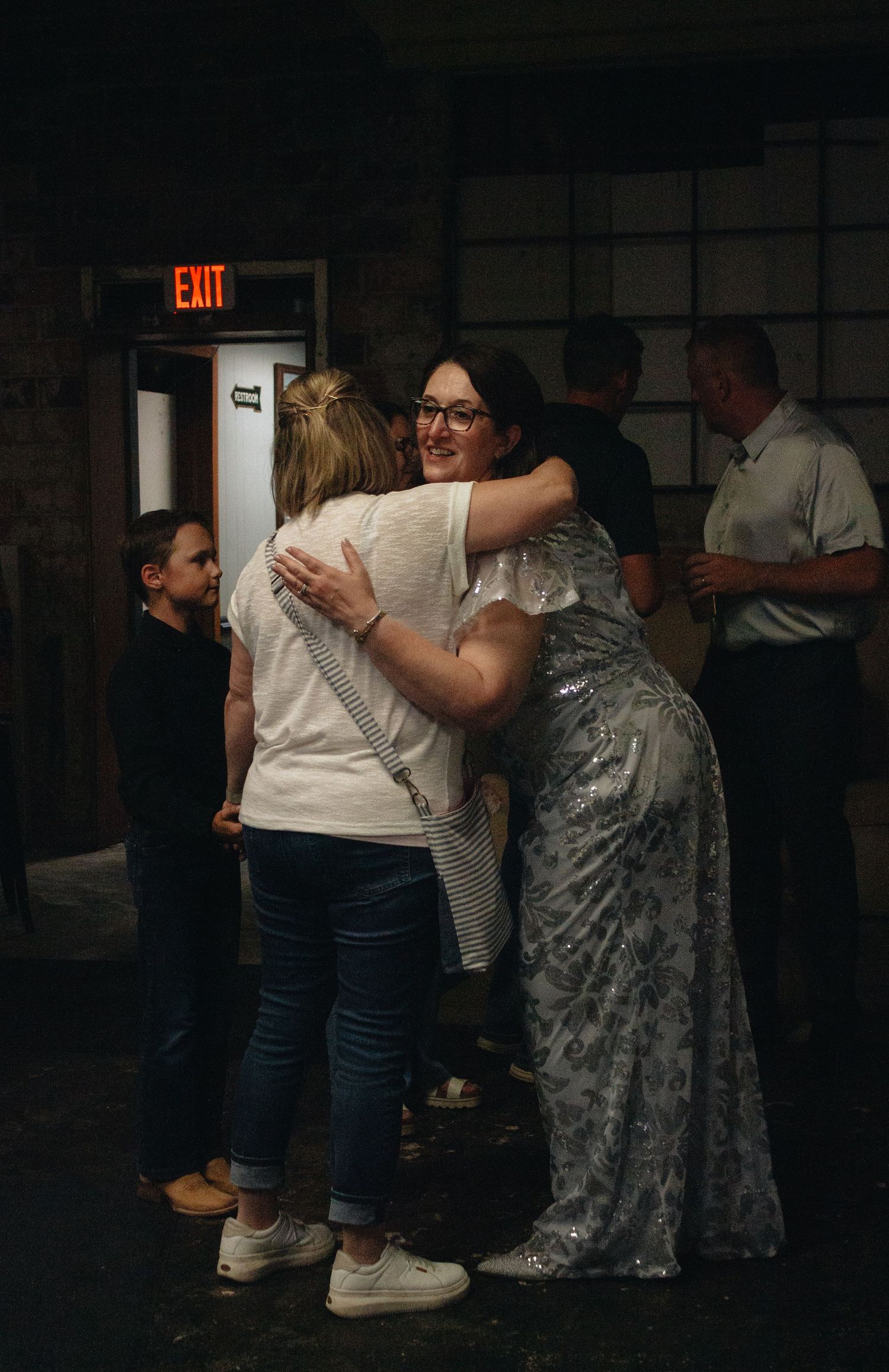 People embracing at an indoor wedding anniversary party.