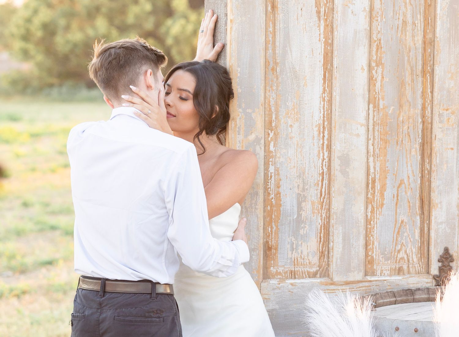 Romantic wedding poses against rustic wooden architecture with barrel details.