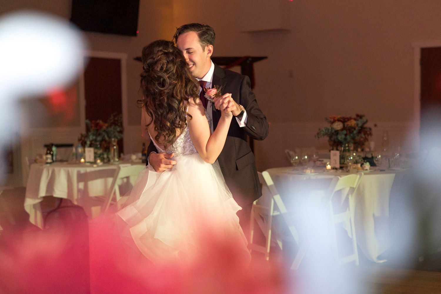 Wedding reception dance floor filled with guests enjoying a celebration in a warmly lit venue.