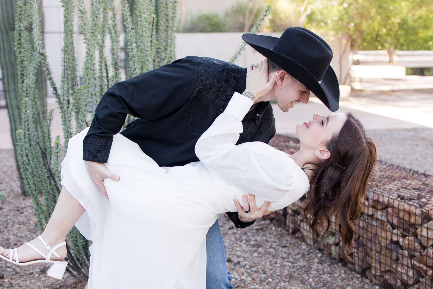 A romantic photo sequence with a couple in western wear posing against desert cacti.