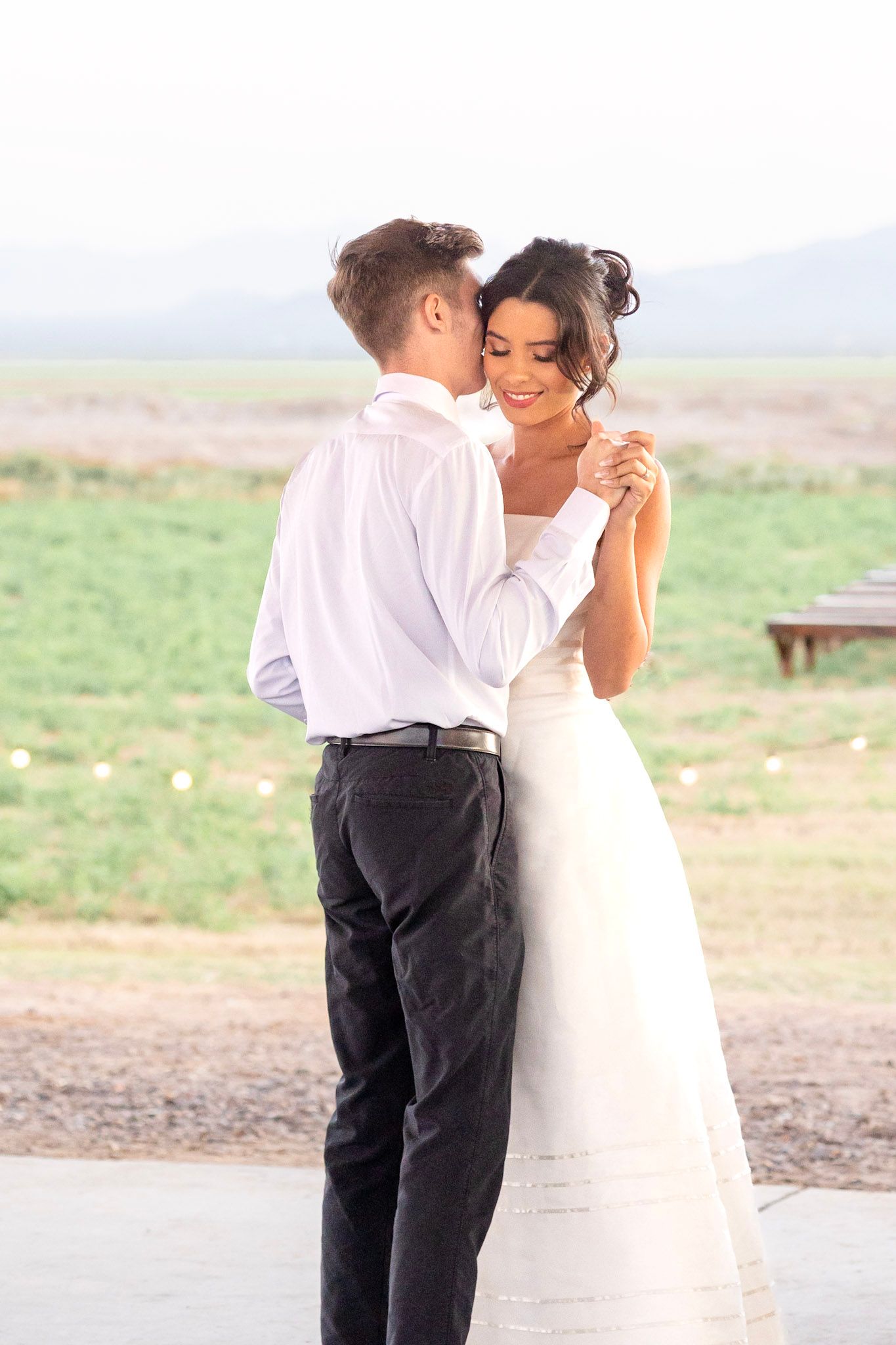 Elegant outdoor photo shoot with white dress and formal attire against a natural desert backdrop.