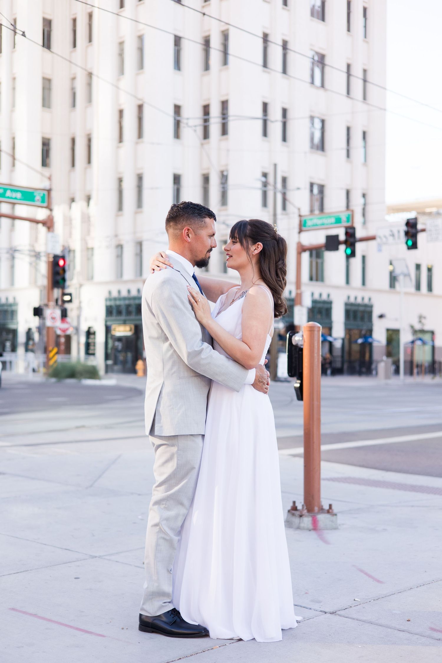 Wedding couple shares romantic moments on an urban street corner.