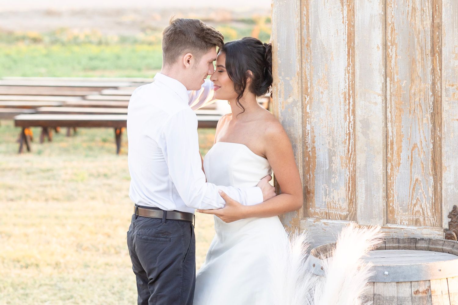Intimate wedding portraits captured against distressed wood walls with rustic barrel decor.