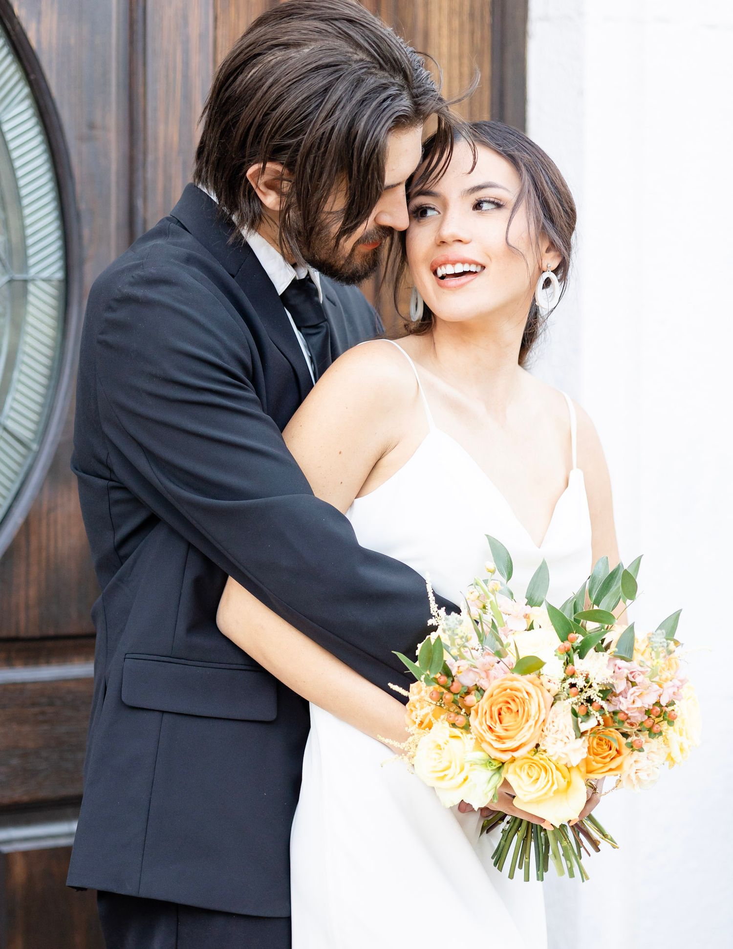 Intimate wedding portraits showing tender moments between newlyweds with peach bouquet. Taken at The Land Mark 809 W. Main St. Mesa, AZ 8520