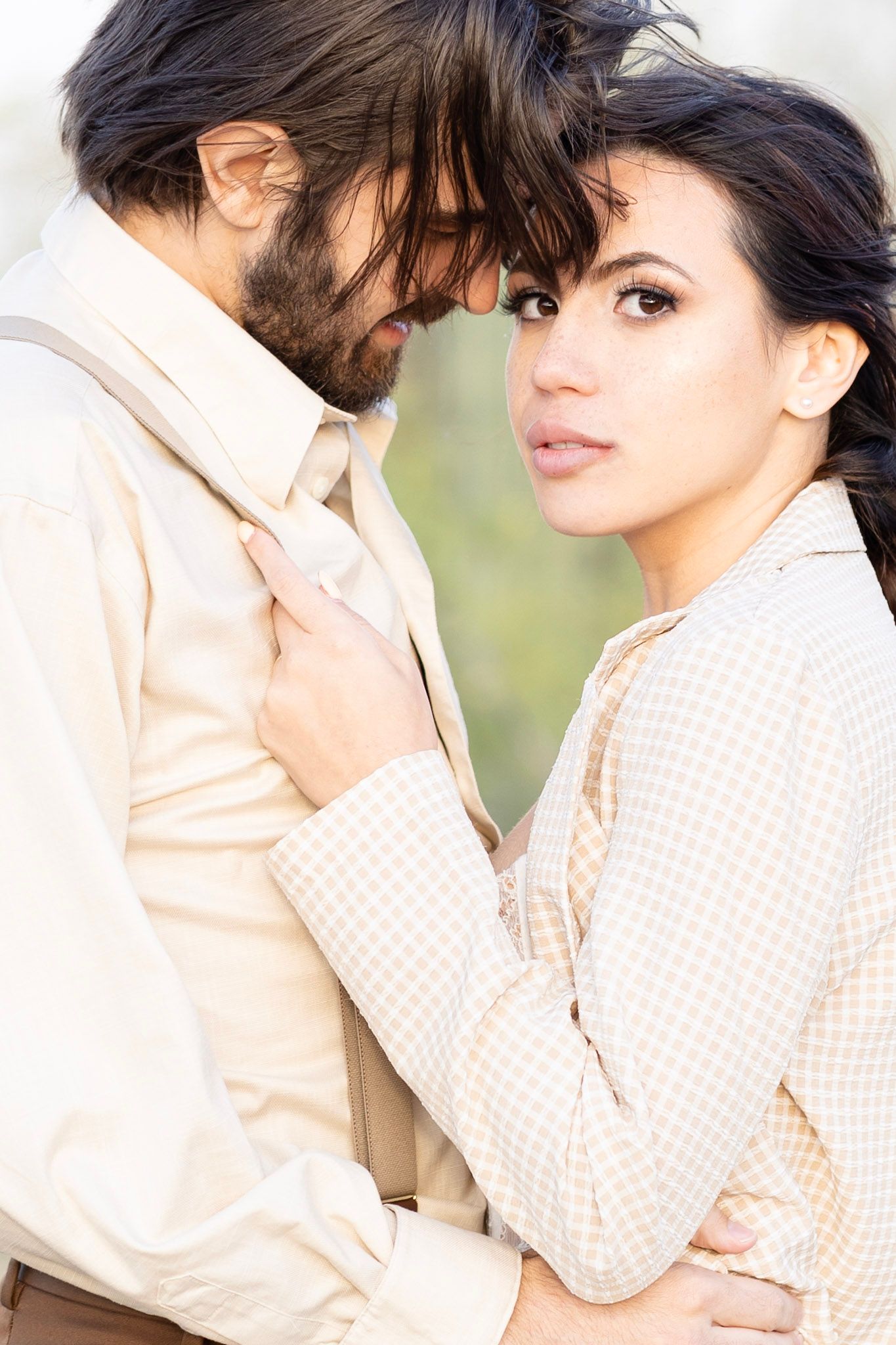 Close-up romantic portraits of couple in vintage attire with soft natural lighting.