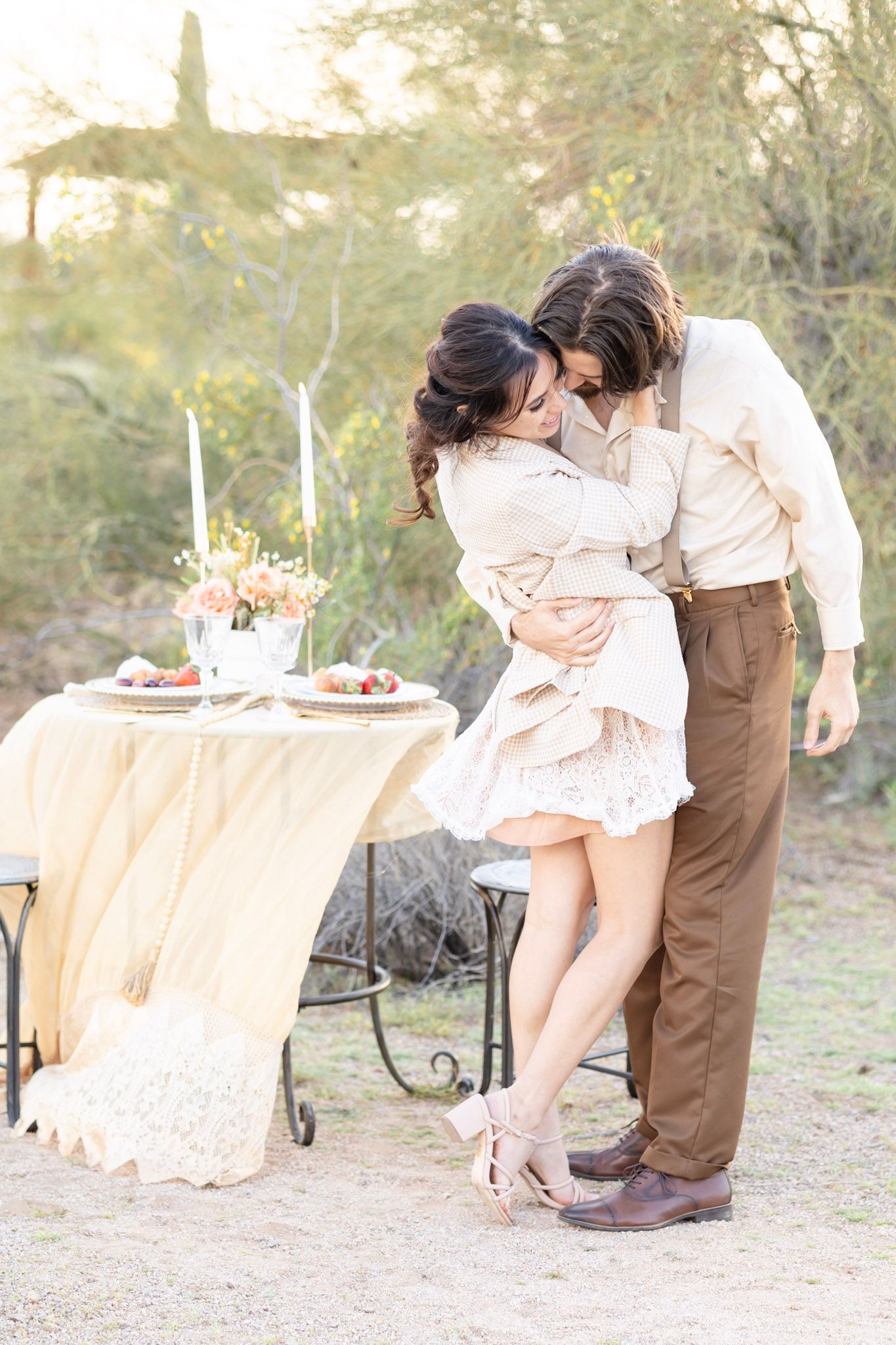 Romantic outdoor photo session with vintage furniture and soft desert lighting.