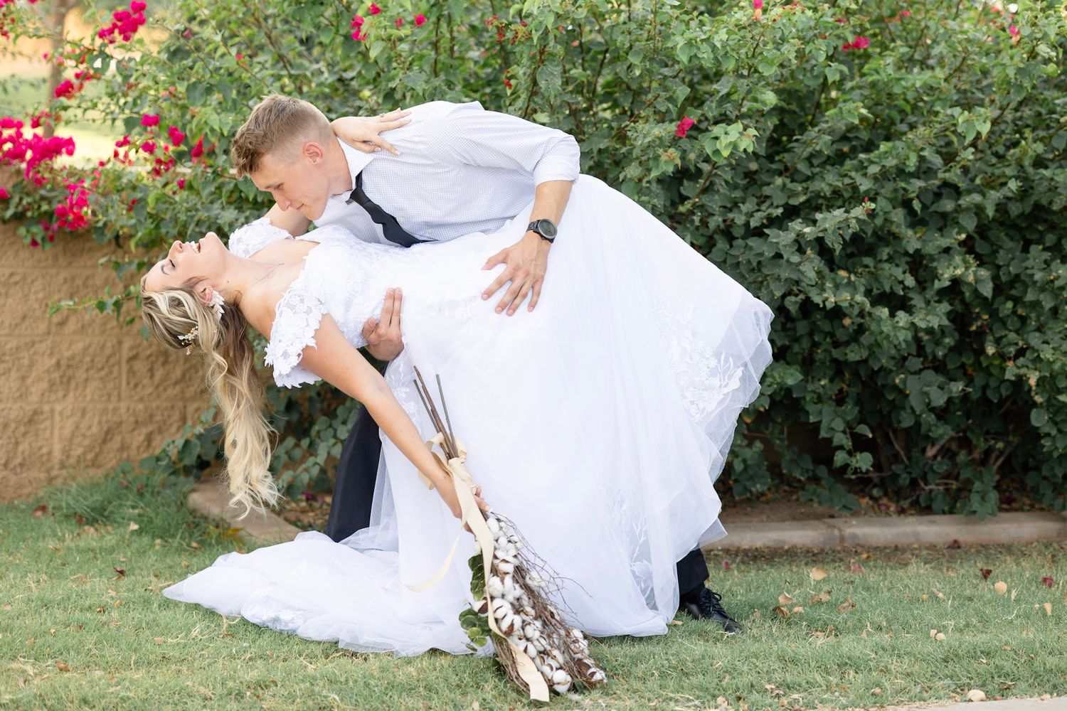 Wedding couple sharing romantic moments among blooming garden flowers.