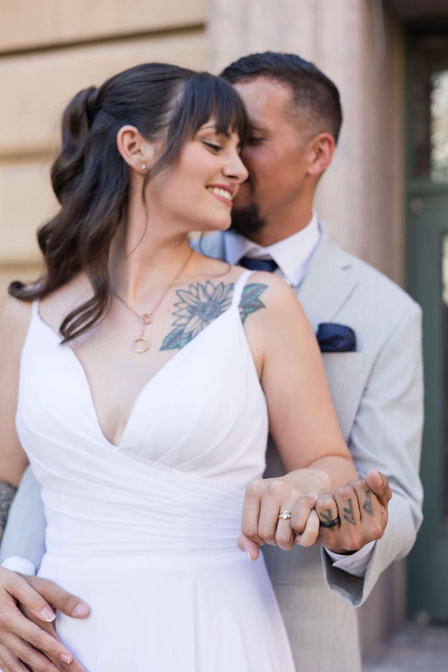 A romantic wedding couple shares intimate moments in a series of photos against a beige building.